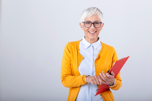 Kostenloses Foto schöne reife geschäftsfrau schriftlich in zwischenablage, isoliert auf weiss porträt senior business-frauen mit zwischenablage und dokument in händen