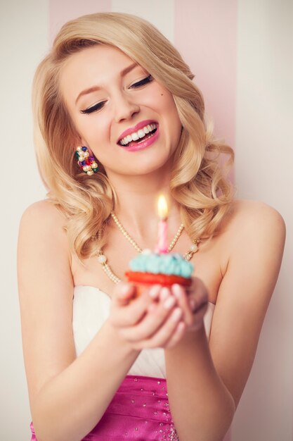 Schöne Retro-Frau feiern mit blauem Muffin