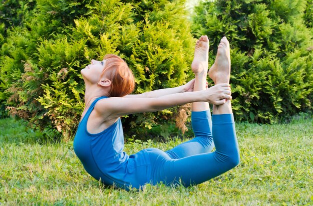 Schöne rote Frau macht Fitness oder Yoga-Übungen