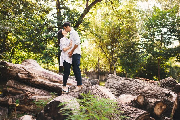 Schöne schwangere Paare, die sich draußen im Wald entspannen