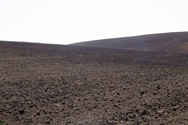 Schöne schwarze Erdfelder in der Ukraine. Landwirtschaftliche ländliche Landschaft, bunte Hügel. Gepflügtes dunkles Land.