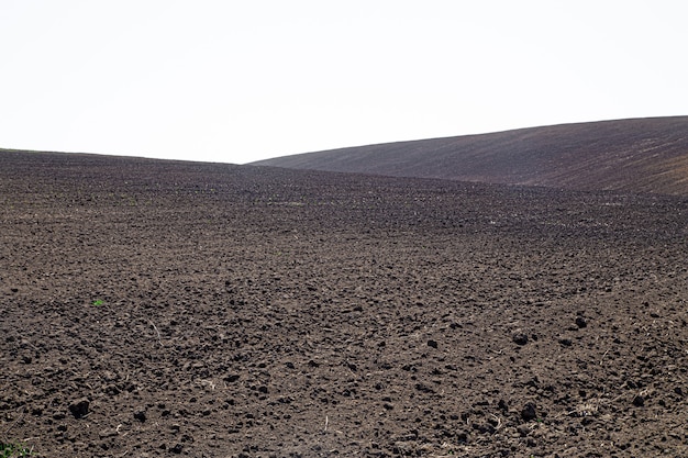 Schöne schwarze Erdfelder in der Ukraine. Landwirtschaftliche ländliche Landschaft, bunte Hügel. Gepflügtes dunkles Land.