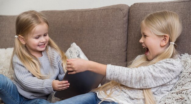 Schöne Schwestern, die Technologie zu Hause verwenden