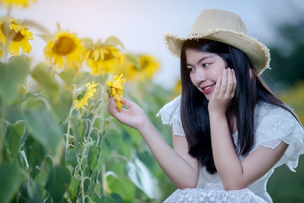 schöne sexy Frau in einem weißen Kleid auf einem Feld von Sonnenblumen, gesunder Lebensstil