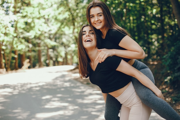 Schöne Sportsgirls in einem sonnigen Park des Sommers