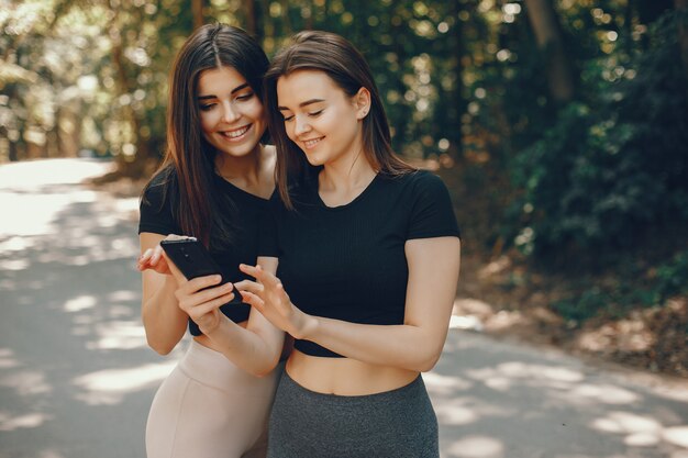 Schöne Sportsgirls in einem sonnigen Park des Sommers