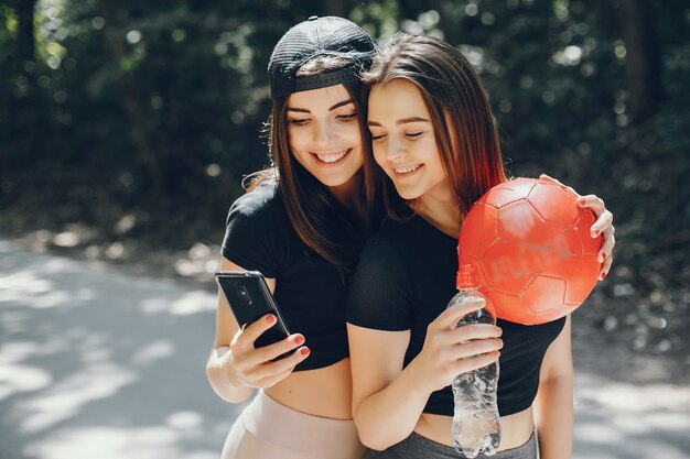 Schöne Sportsgirls in einem sonnigen Park des Sommers