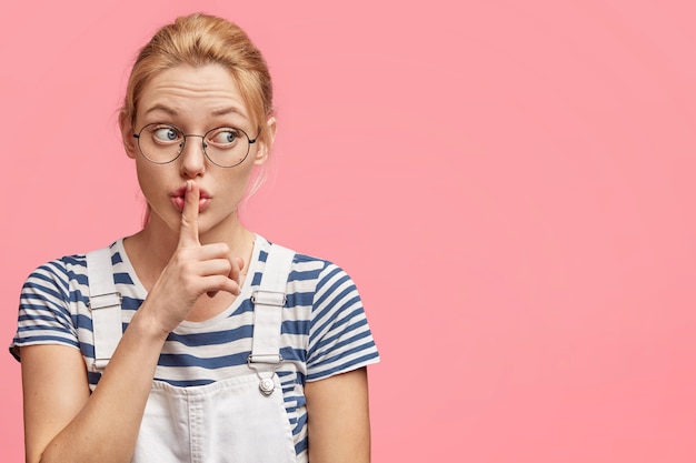 Kostenloses Foto schöne studentin hält vorderfinger in stiller geste