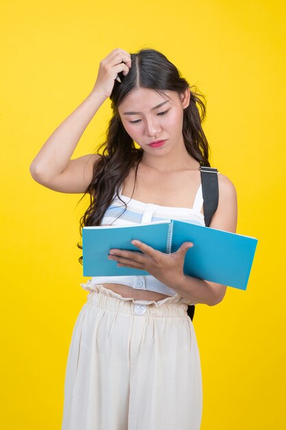 Schöne Studentinnen halten Notizbücher und Stifte