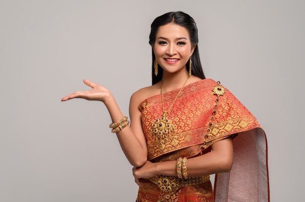 Schöne thailändische Frau, die ein thailändisches Kleid und ein glückliches Lächeln trägt.