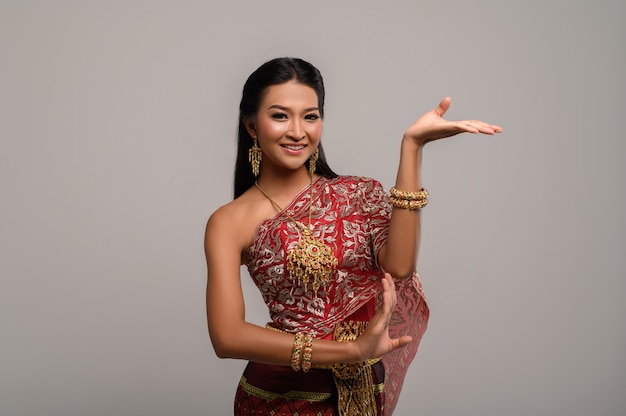 Schöne thailändische Frau, die thailändisches Kleid und thailändischen Tanz trägt