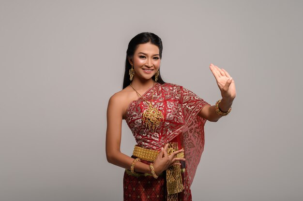 Schöne thailändische Frau, die thailändisches Kleid und thailändischen Tanz trägt