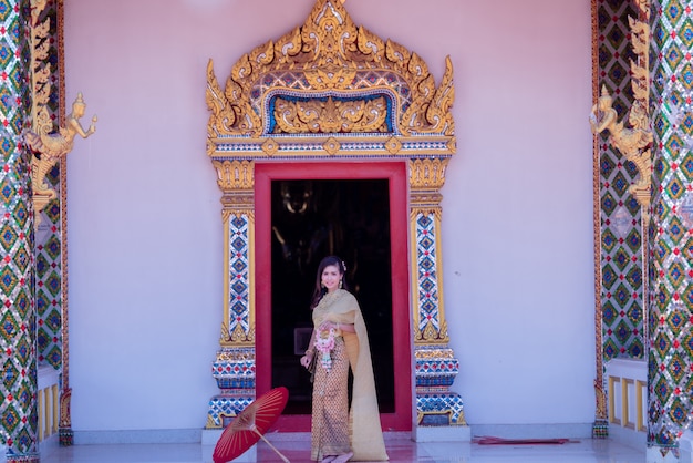 Schöne thailändische Frau im Trachtenkostüm am Tempel von Thailand