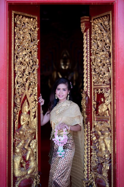 Schöne thailändische Frau im Trachtenkostüm am Tempel von Thailand