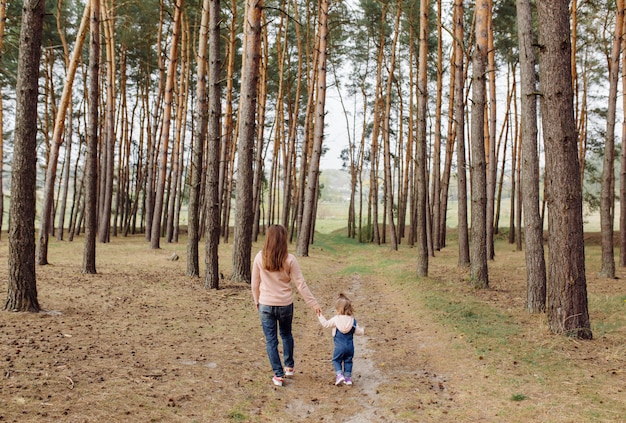 Schöne und glückliche Mutter und Tochter, die eine gute Zeit im Wald haben