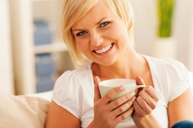 Schöne und lächelnde Frau mit einer Tasse Kaffee