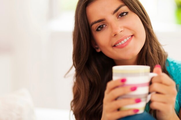 Schöne und lächelnde Frau mit einer Tasse Kaffee