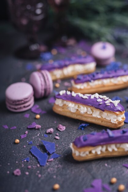 Schöne und leckere lila Eclairs und Makronen mit Lavendel Bouquet