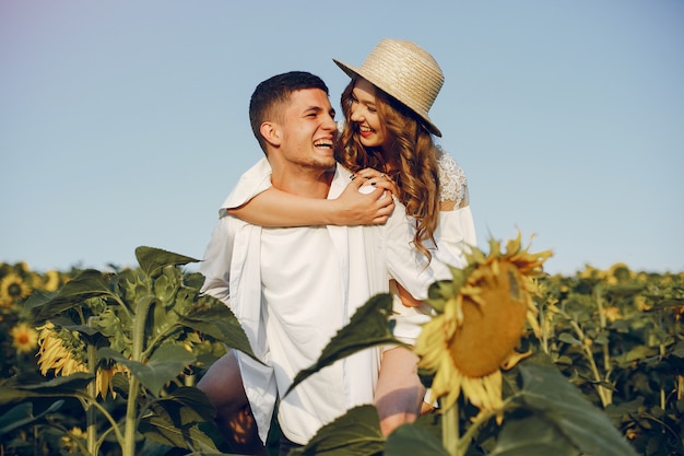 Schöne und stilvolle Paare auf einem Gebiet mit Sonnenblumen