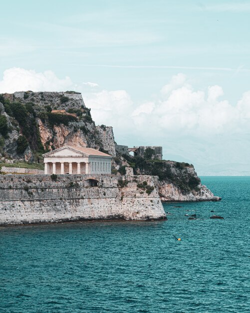 Schöne vertikale Aufnahme eines alten Tempels und des Meeres in einer der griechischen Inseln