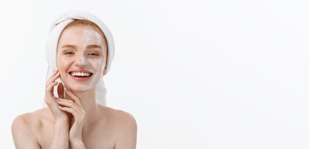 Schöne vorbildliche zutreffende kosmetische Sahnebehandlung auf ihrem Gesicht auf Weiß