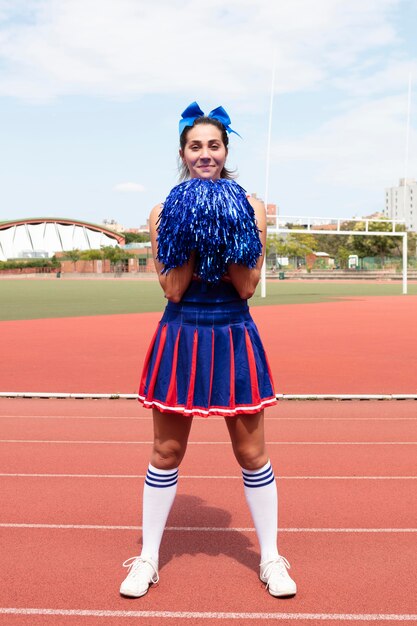 Schöne weibliche Cheerleaderin in süßer Uniform