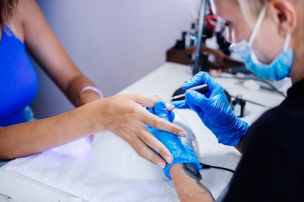 Schöne weibliche Hände Finger Nagelbehandlung Herstellungsprozess Professionelle Nagelfeile Bohrer in Aktion Schönheits- und Handpflegekonzept