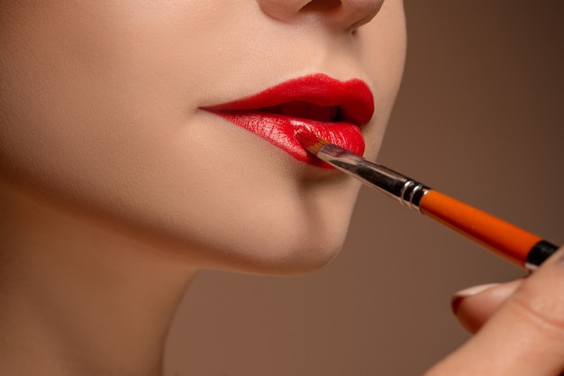 Schöne weibliche Lippen mit Make-up und Pinsel