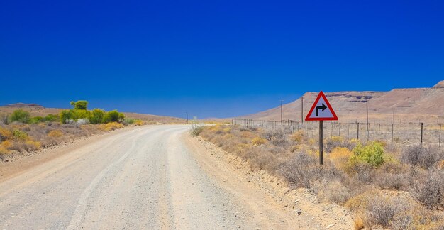 Schöne Wüstenlandschaft rund um eine Schotterstraße in der Karoo von Südafrika