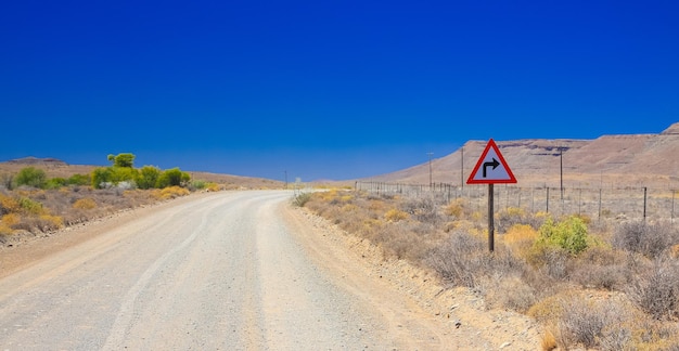 Schöne Wüstenlandschaft rund um eine Schotterstraße in der Karoo von Südafrika