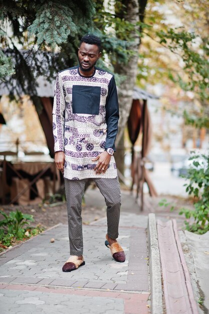 Schöner afroamerikanischer Mann in traditioneller Kleidung in der modernen Stadt