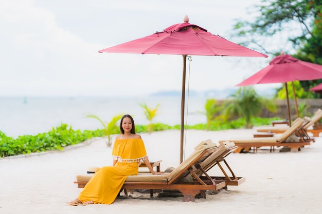 Schöner asiatischer Frauenabnutzungshut des Porträts mit glücklicher Freizeit des Lächelns auf dem Strandseeozean in den Feiertagsferien