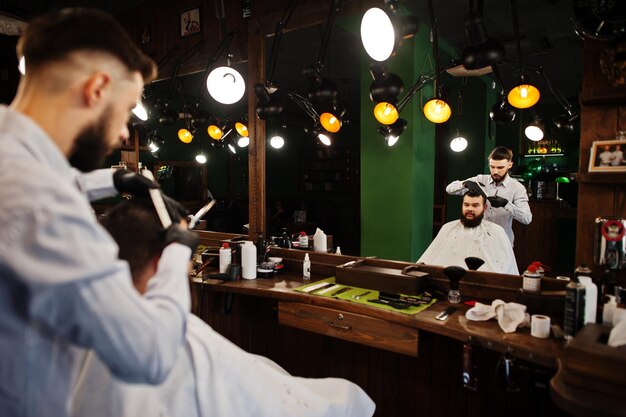 Schöner bärtiger Mann im Friseursalon bei der Arbeit