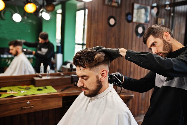 Schöner bärtiger Mann im Friseursalon bei der Arbeit