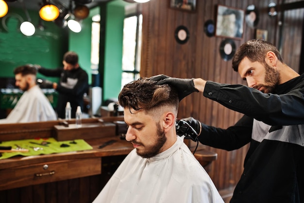 Schöner bärtiger Mann im Friseursalon bei der Arbeit