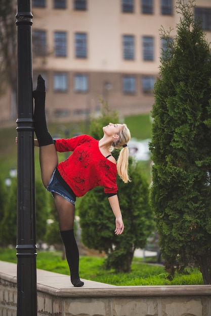 Schöner Balletttänzer oder akrobatischer Tanz draußen auf der Straße