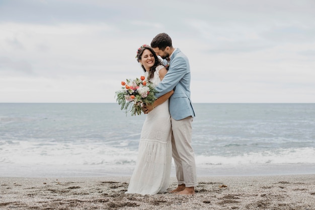 Schöner Ehemann und Ehefrau posieren am Strand