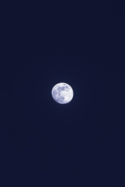 Schöner einsamer weißer Mond im dunkelblauen Himmel