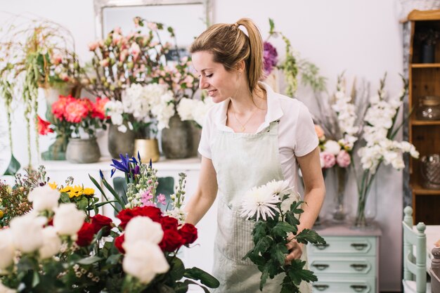 Schöner Florist, der Blumen im Shop anordnet