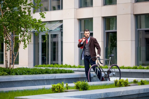 Schöner Geschäftsmann und sein Fahrrad