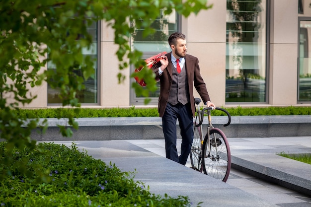 Schöner Geschäftsmann und sein Fahrrad