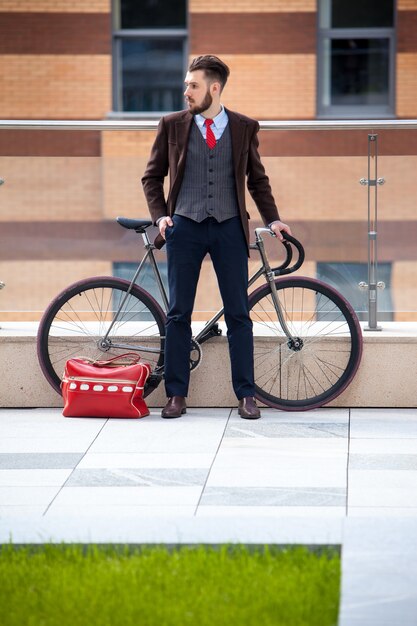 Schöner Geschäftsmann und sein Fahrrad