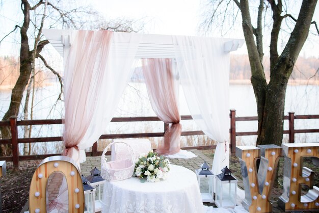 Schöner Hochzeitsaltar aus weißen und rosa Vorhängen