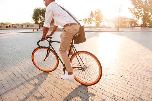 Schöner junger afrikanischer Mann am frühen Morgen mit Fahrrad