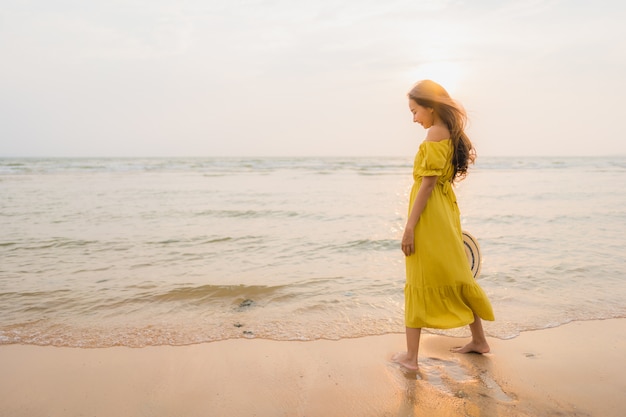 Schöner junger asiatischer Frauenweg des Portraits auf dem Strand- und Seeozean mit dem glücklichen Lächeln entspannen sich