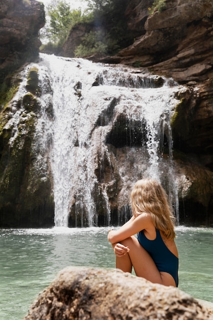 Schöner junger Erwachsener am Wasserfall