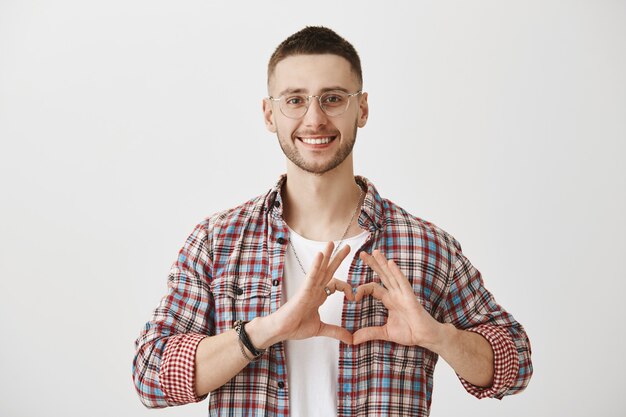 Schöner junger Mann mit Brille posiert