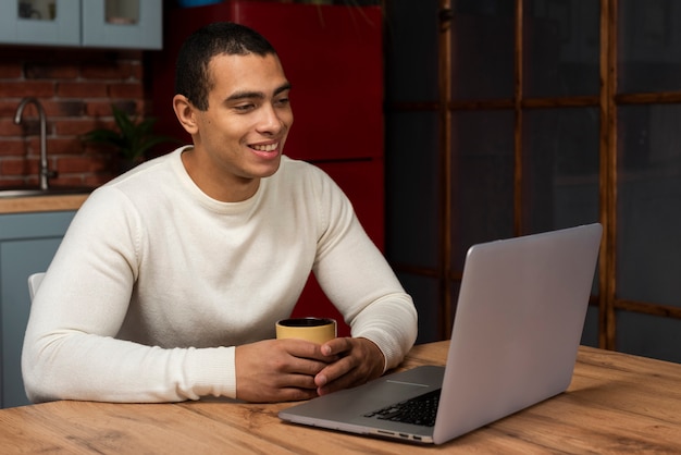 Schöner junger Mann mit einem Laptop