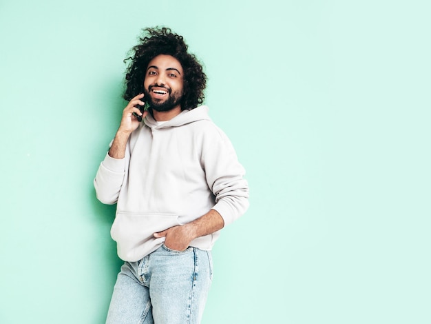 Schöner lächelnder Hipster-Mann, der im Studio posiert