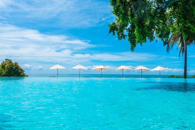 Schöner Luxusregenschirm und -stuhl um Swimmingpool im Hotel und im Erholungsort